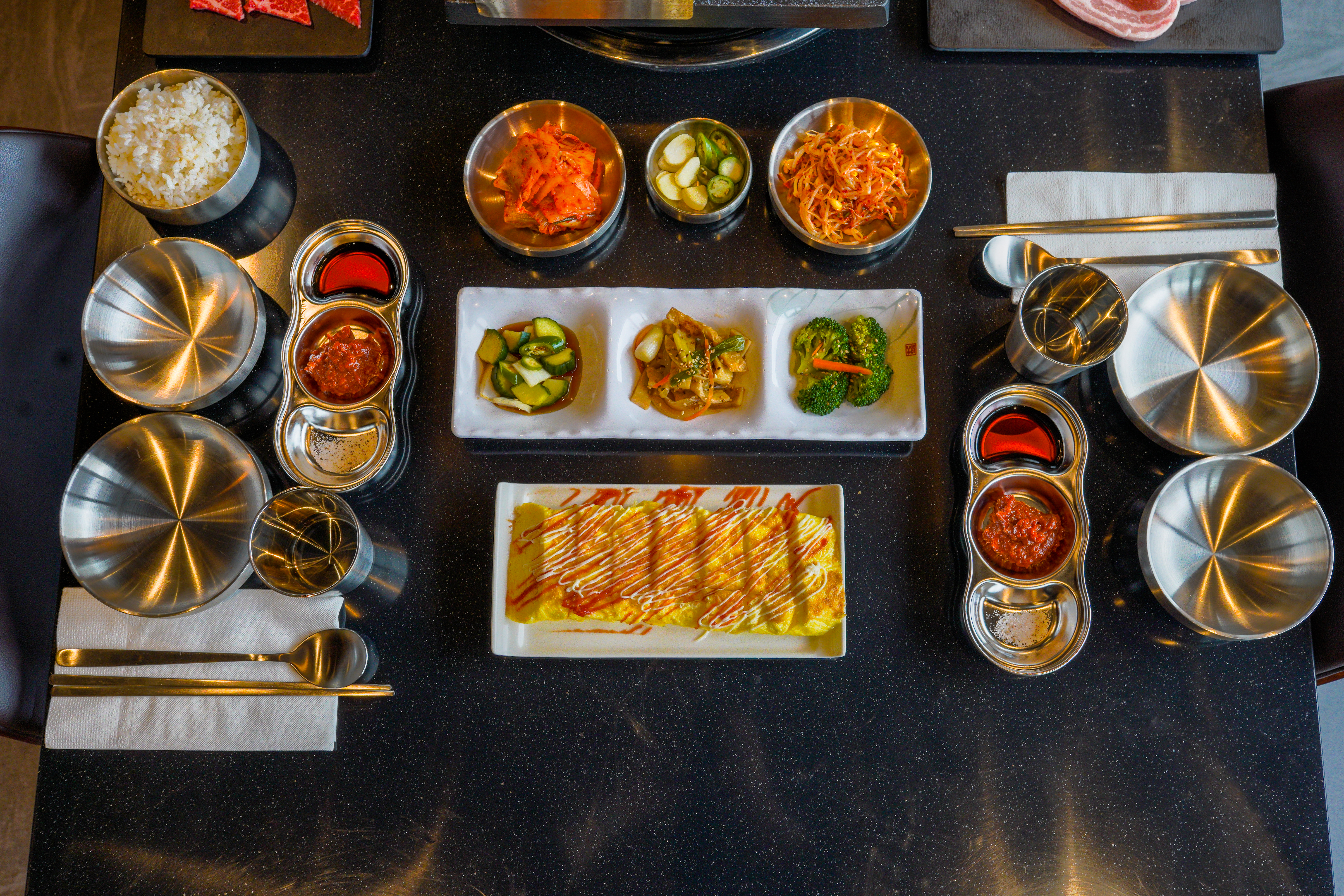 Banchan - Traditional Korean side dishes including kimchi, pickled vegetables, and seasoned greens
